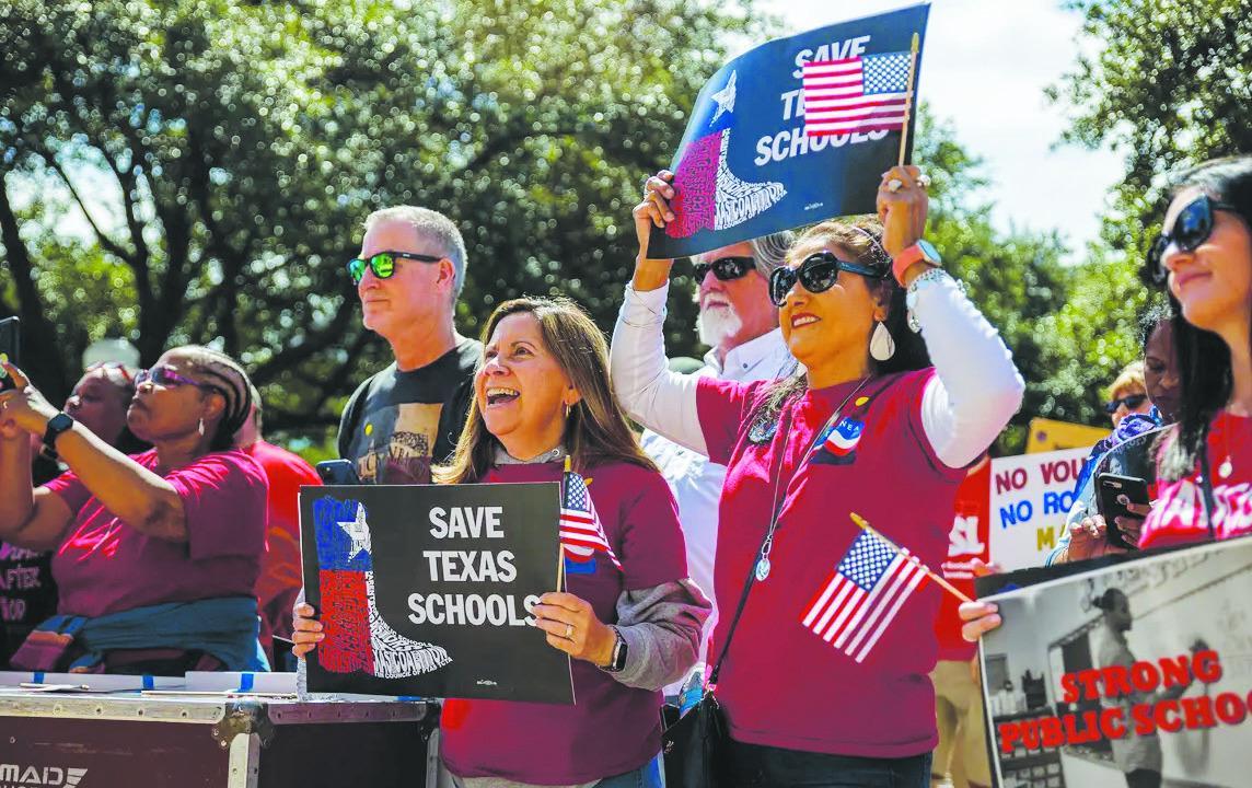 Protesters hold signs and chant during a rally against school vouchers at the Texas Capitol on Saturday. Julius Shieh/The Texas Tribune