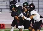 PHOTOS BY P.J. HERNANDEZ/ Advance News Journal Top: Palmview's Edgar Villalpando makes a handoff to Abram Martinez against the PSJA Memorial Wolverines on Friday. Above: PSJA Memorial’s Joshua Bautista gets dragged down by La Joya Palmview defenders on 